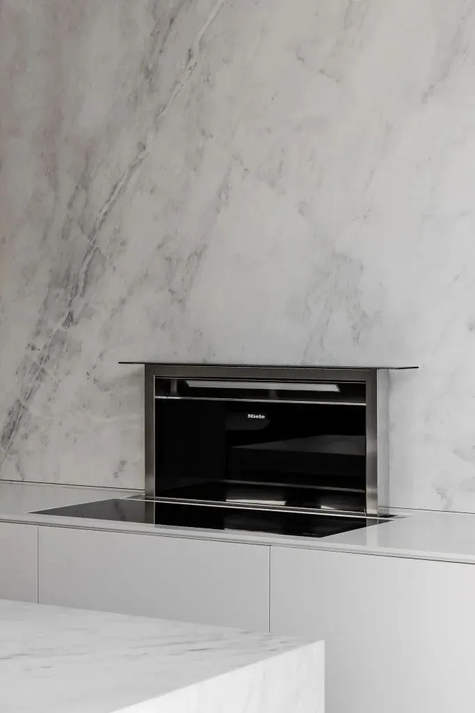 Modern kitchen with marble countertops, backsplash, and wall