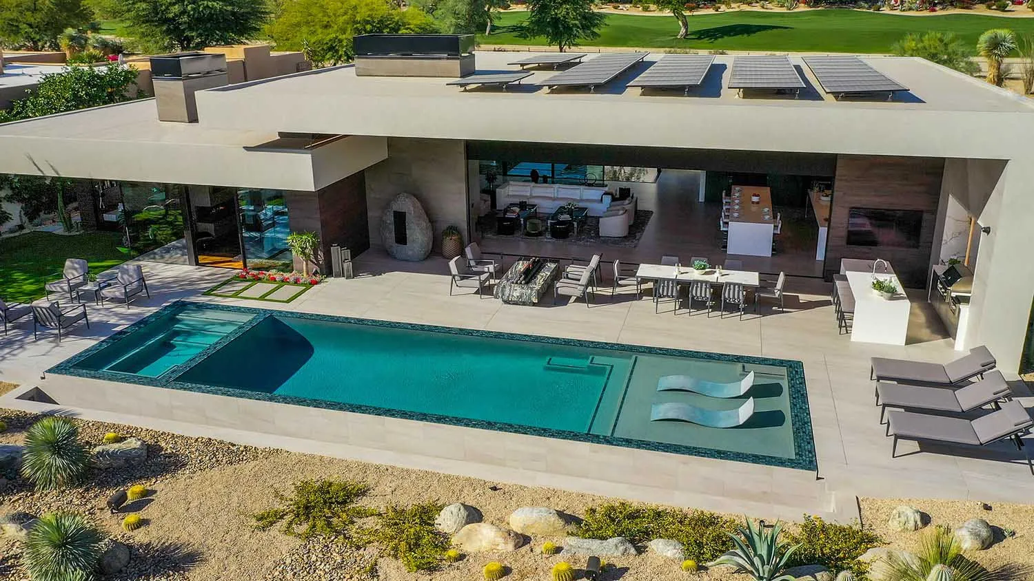 Modern residential outdoor space featuring a swimming pool with concrete and glass elements.