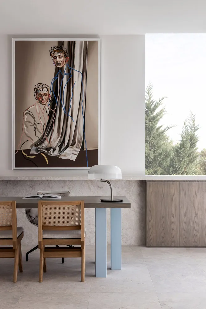 Modern dining room with abstract painting, wooden table, and chairs.
