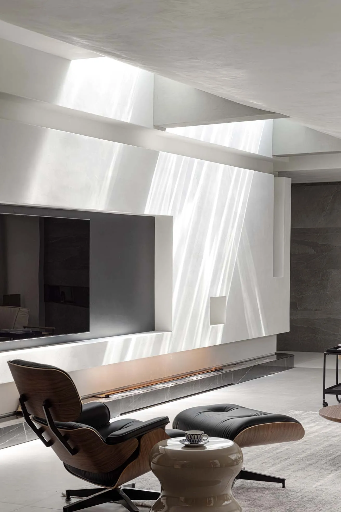 A modern living room featuring a concrete wall, wooden accents, and glass elements.