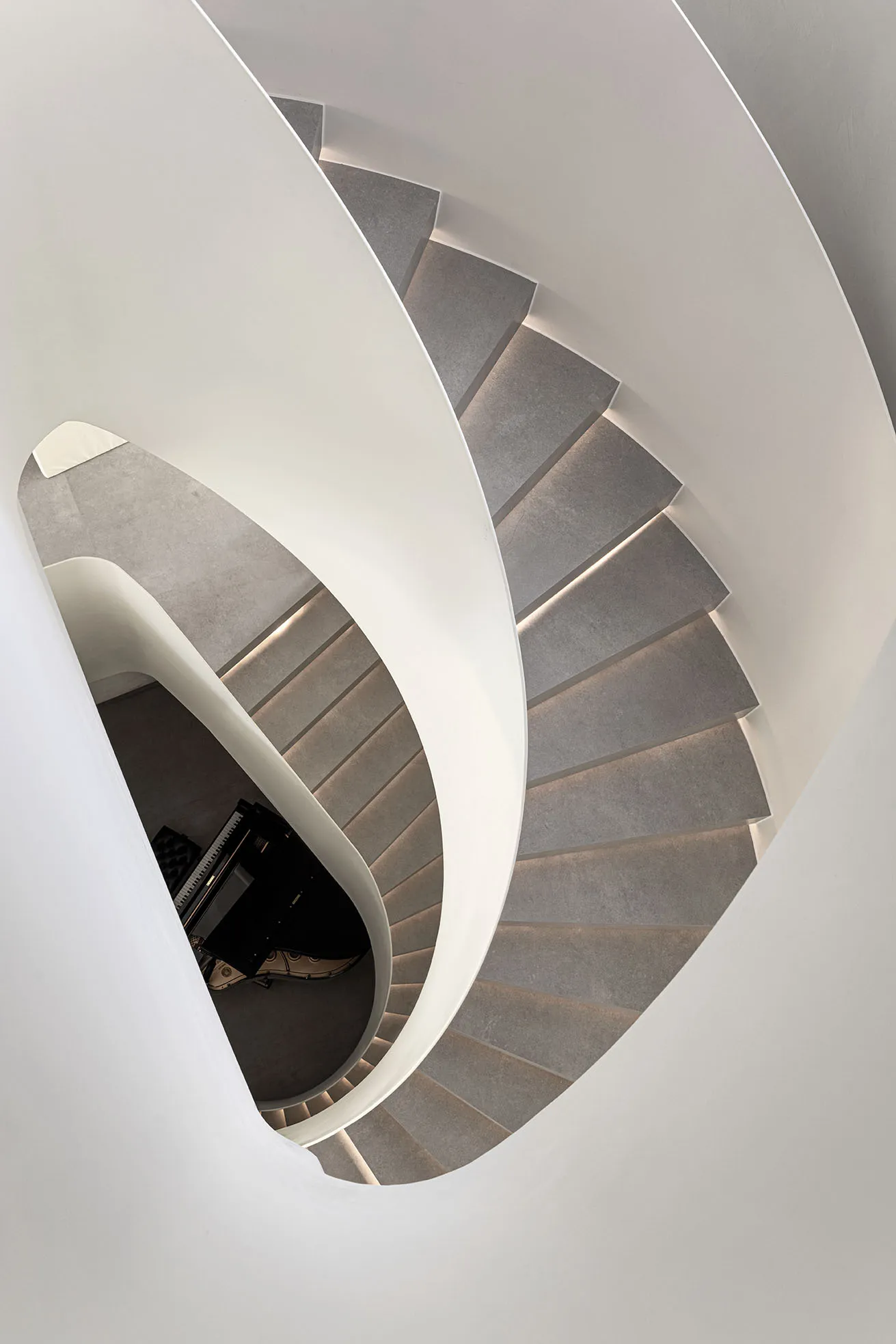 A modern white staircase with concrete steps and lighting.