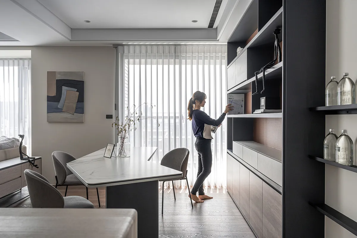 A minimalist living room with a wooden floor, glass shelves, and a sleek design.