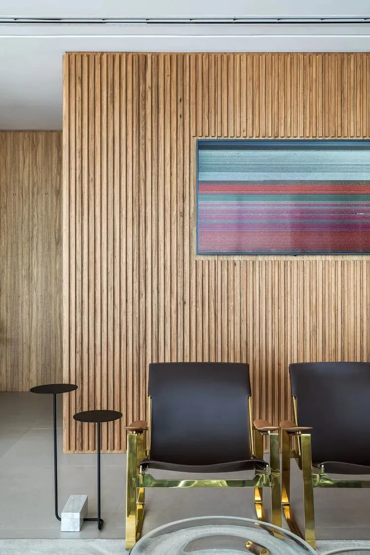 Modern office waiting area featuring a wooden accent wall and metallic chairs.