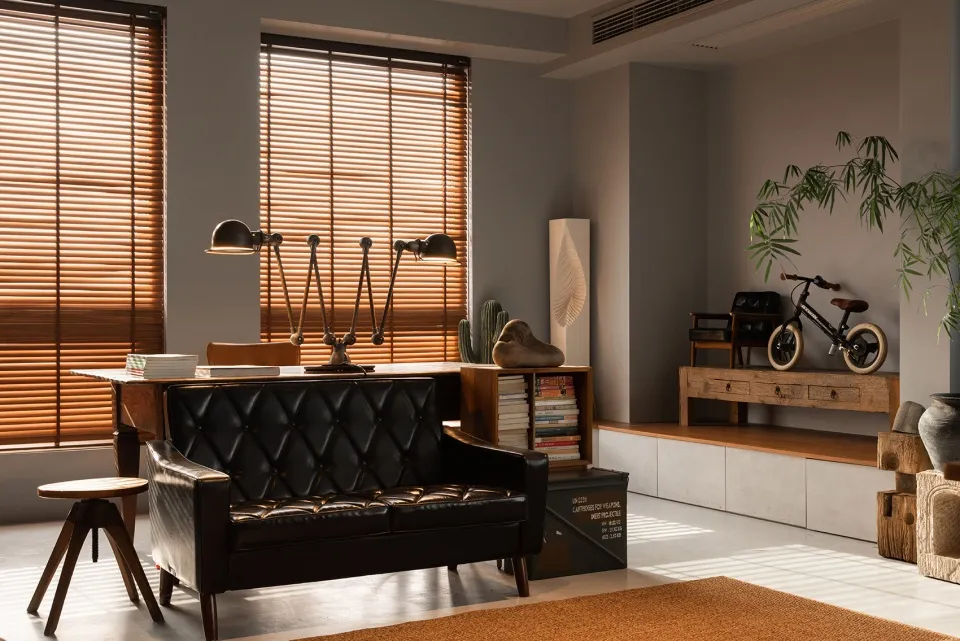 A modern industrial living room featuring wooden blinds and a leather sofa, with a focus on the minimalist design and the use
