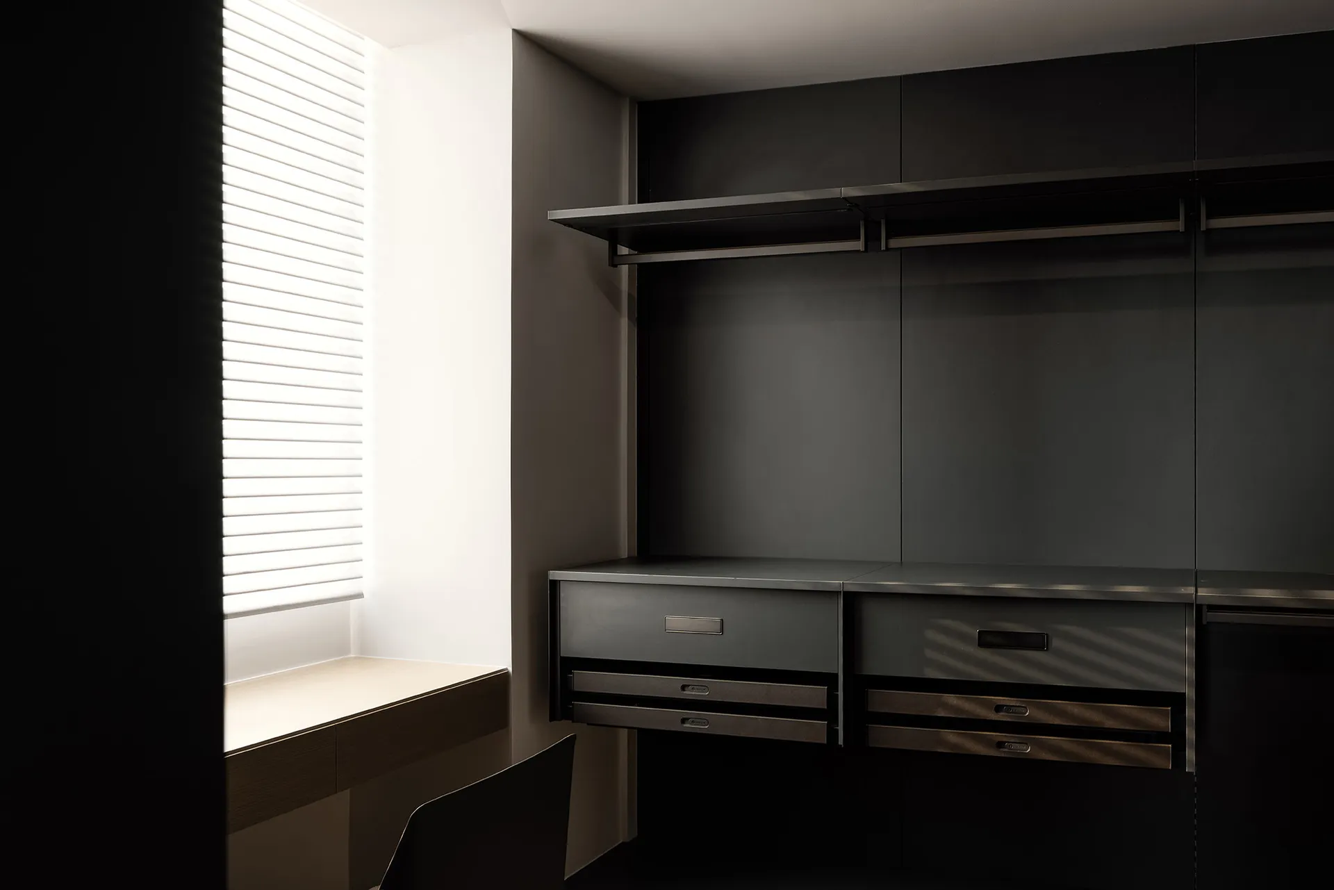 Modern minimalist closet with metal finishes and integrated storage solutions.