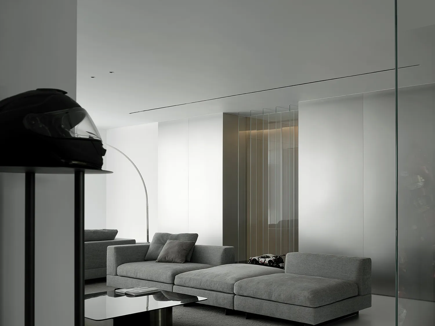 Minimalist living room with fabric seating and glass walls.