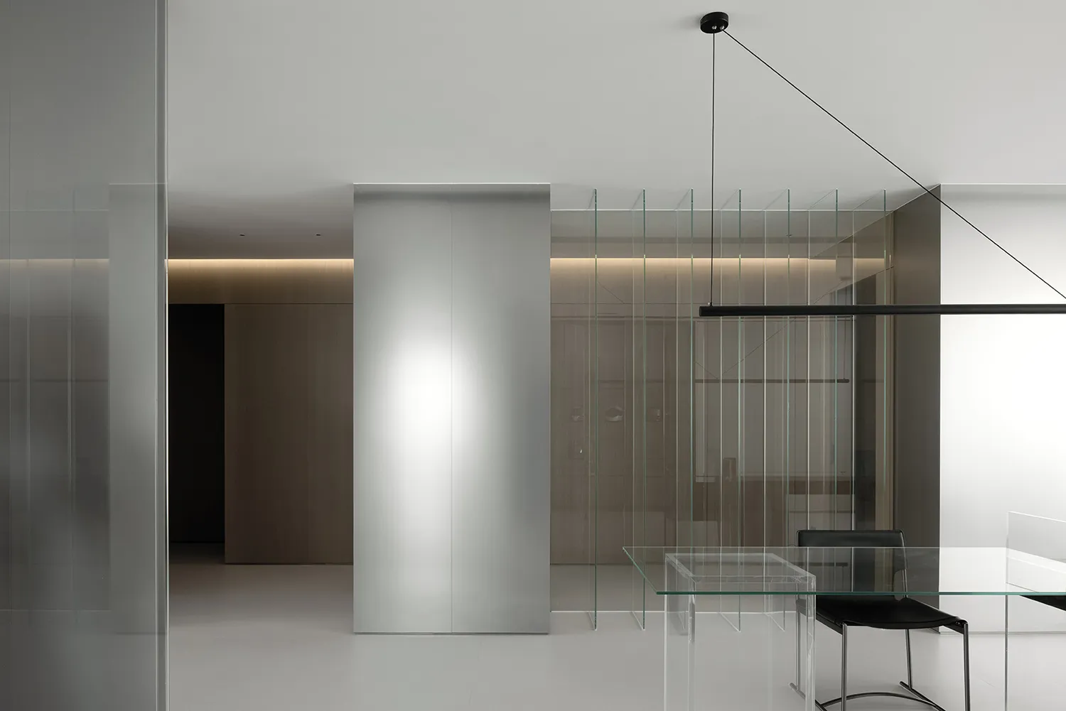 Modern minimalist office interior with glass walls and metal accents.