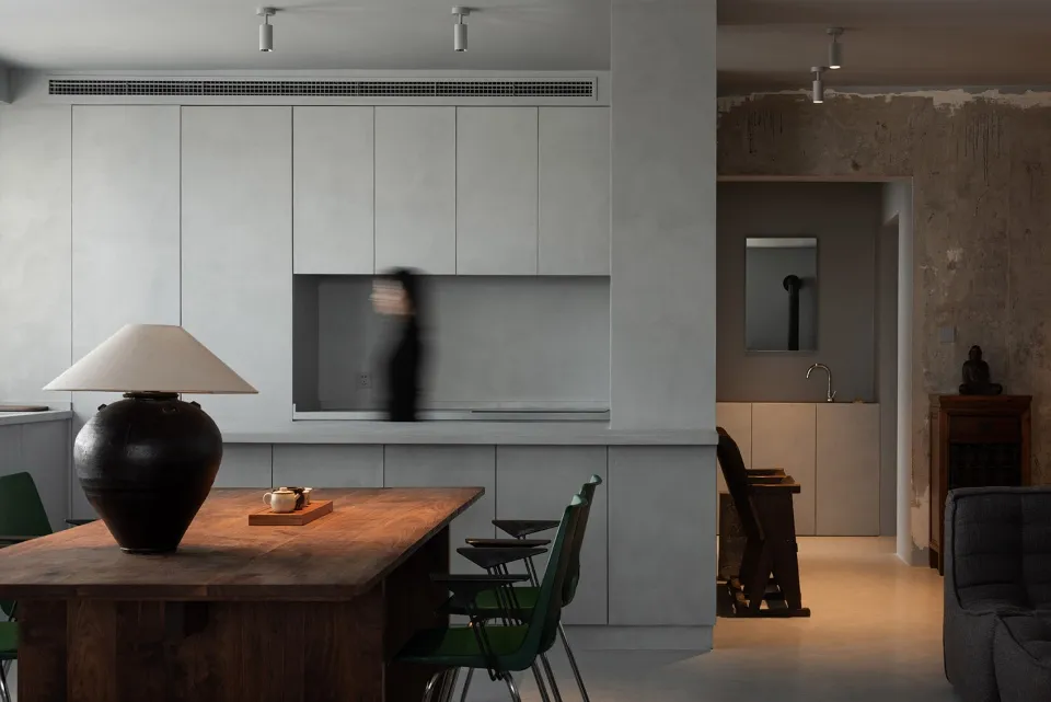 A modern residential kitchen featuring concrete countertops and wooden cabinets.