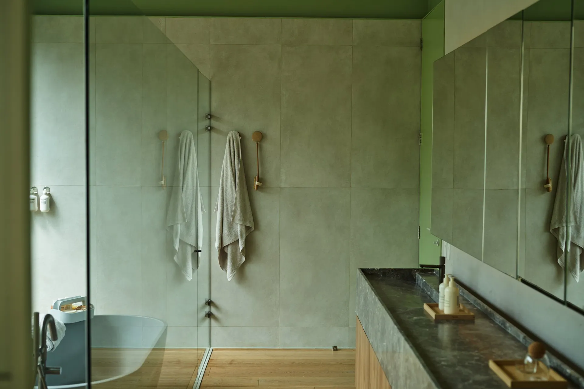 A modern bathroom featuring concrete walls, minimalistic design, and a Zen-like atmosphere with natural lighting and floor-to