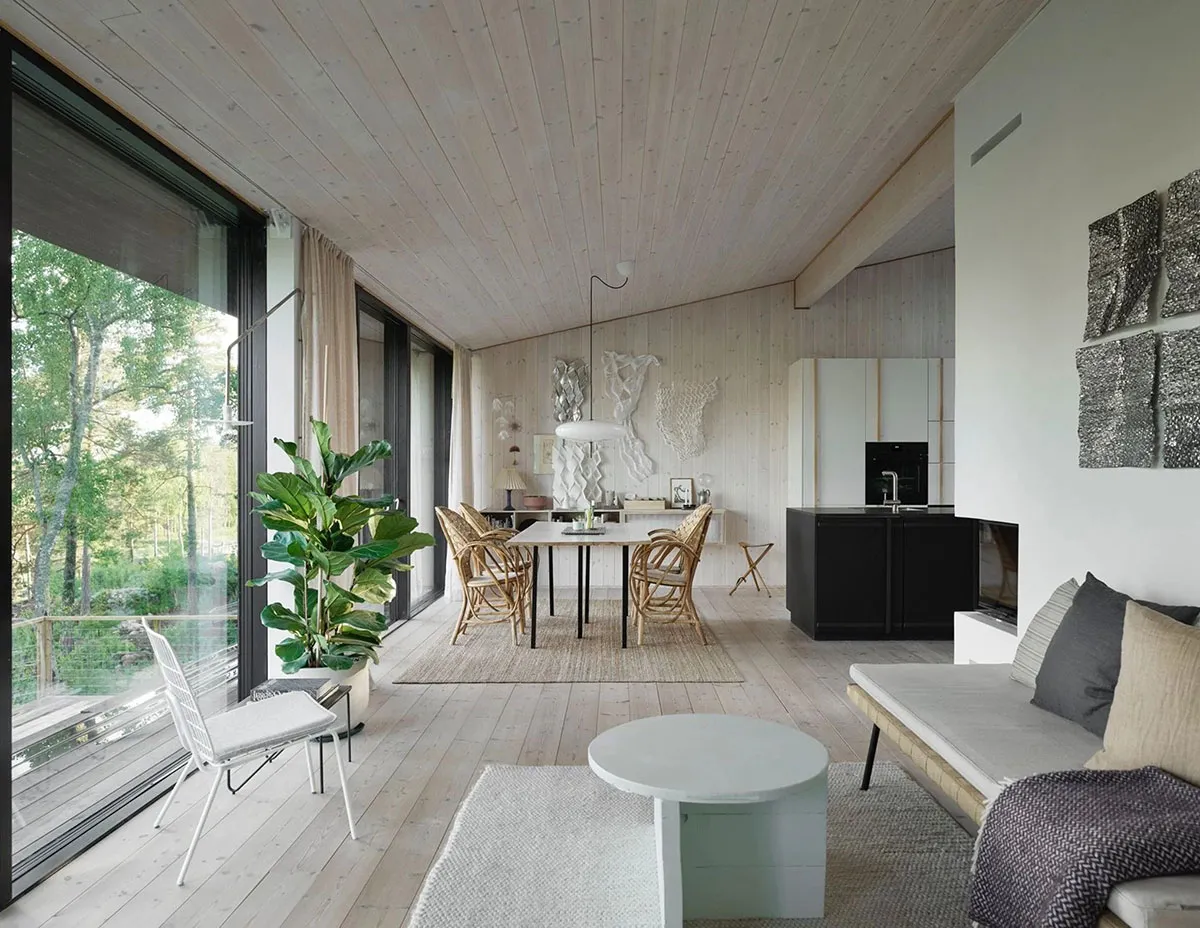 A minimalist living room featuring wood flooring and walls, with a white sofa and circular coffee table.