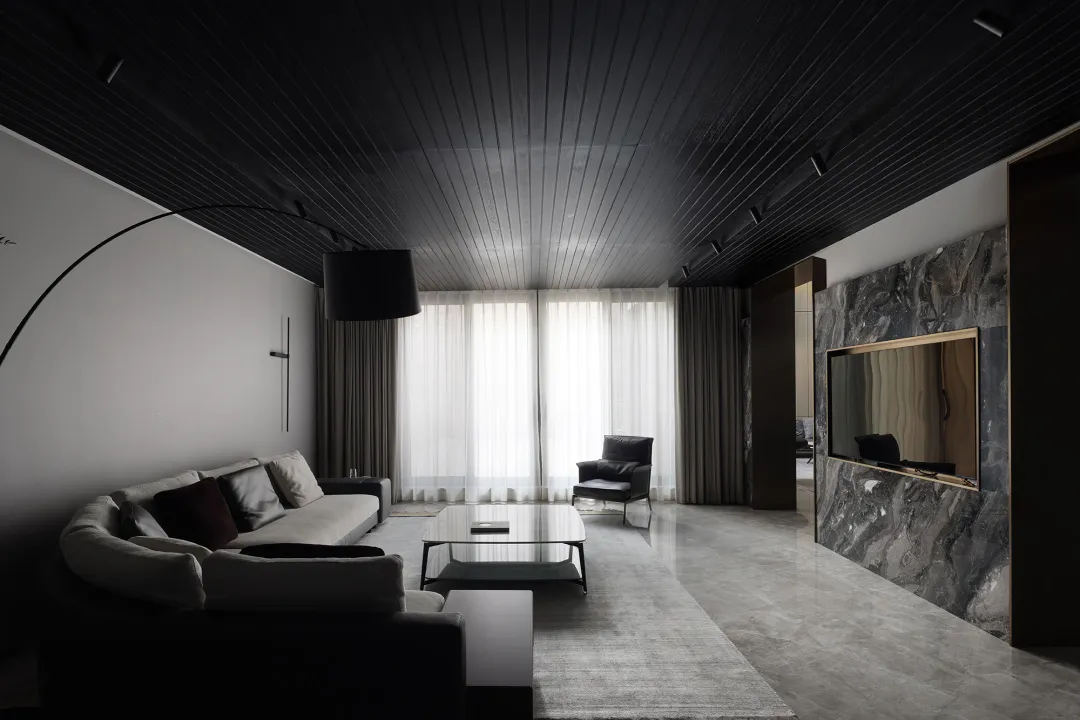 A modern minimalist living room featuring marble materials and a sleek, contemporary design.