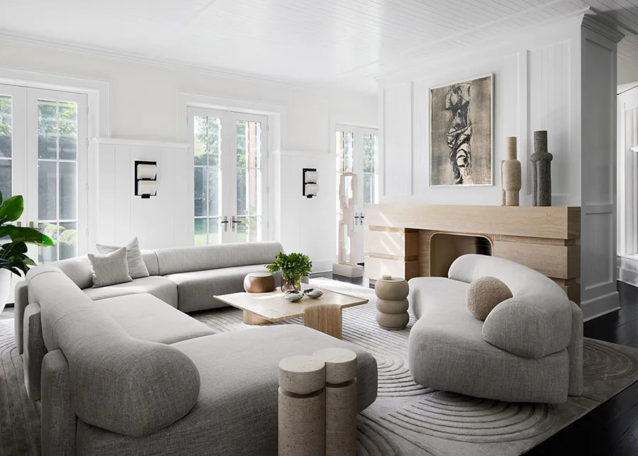 A spacious, minimalist living room with white walls, a large modern sofa, and a wood-burning fireplace.