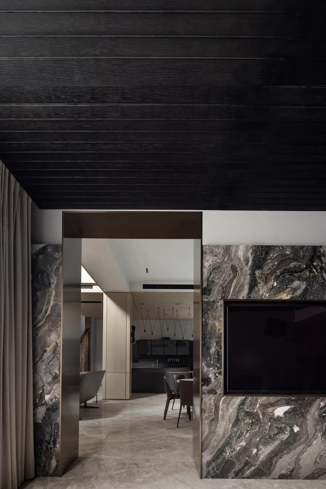 Modern, minimalist kitchen area with marble countertops and dark wood accents.