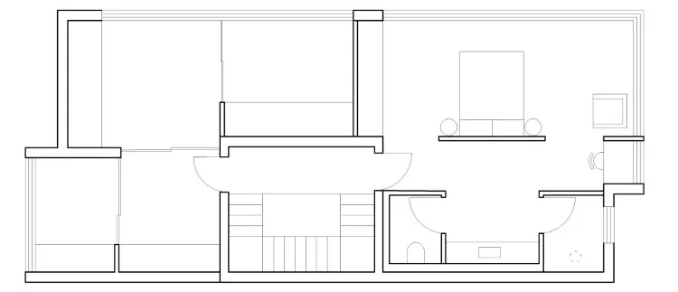 Floor plan of a minimalist residential layout depicting a living area with a couch and table, a bedroom with a bed, and a bat