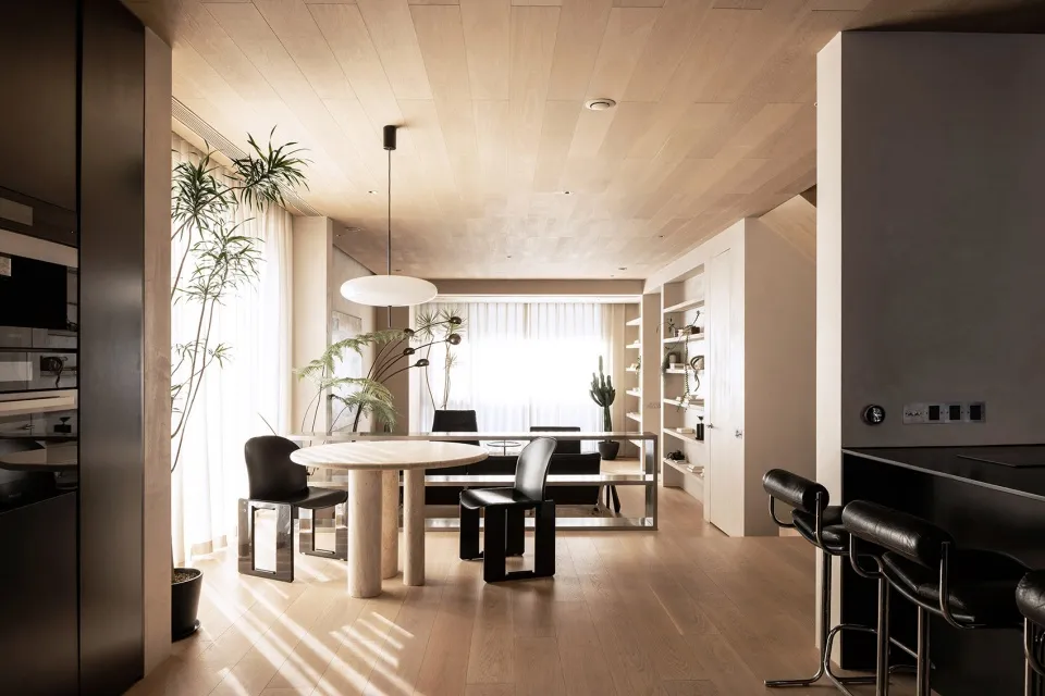 Modern living room with wooden flooring, furniture, and plants.