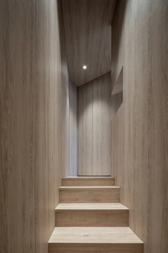 Modern interior space with wooden stairs and walls.
