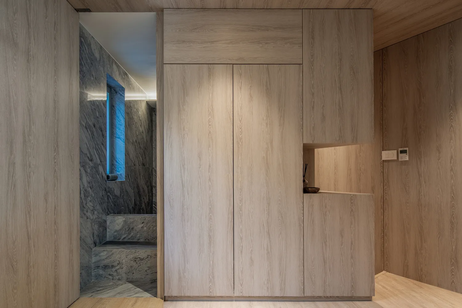 A modern kitchen with minimalist design, featuring wood cabinets.