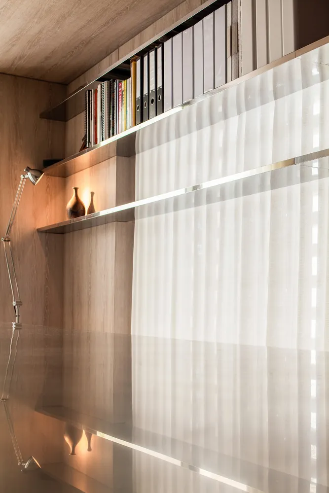 A modern library with transparent glass and wooden shelves.