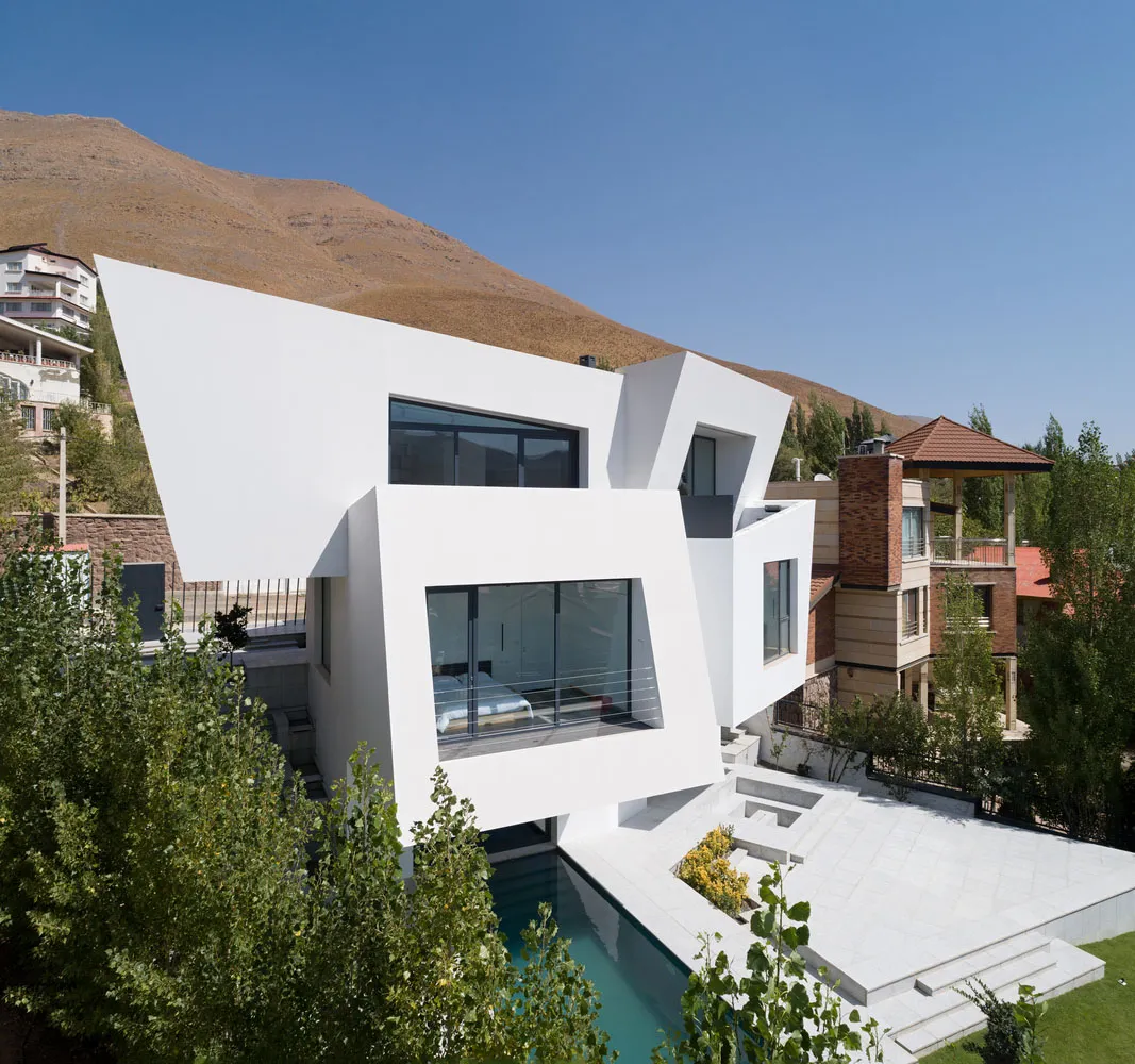 A modern residential concrete home with a white exterior and large windows.
