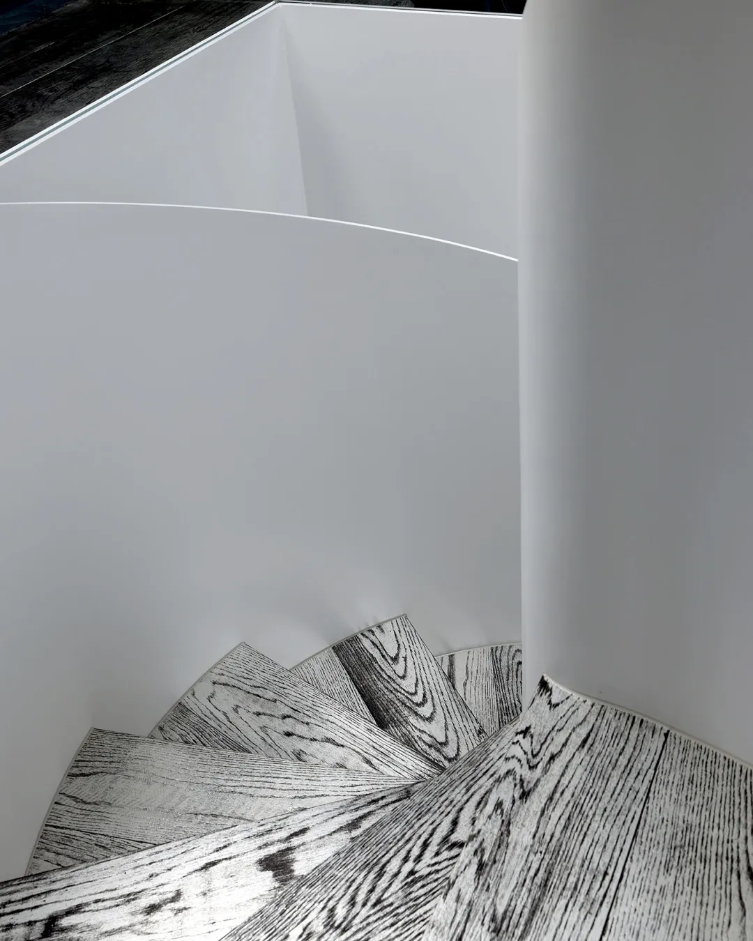 A minimalist staircase with wooden steps viewed from a camera angle.