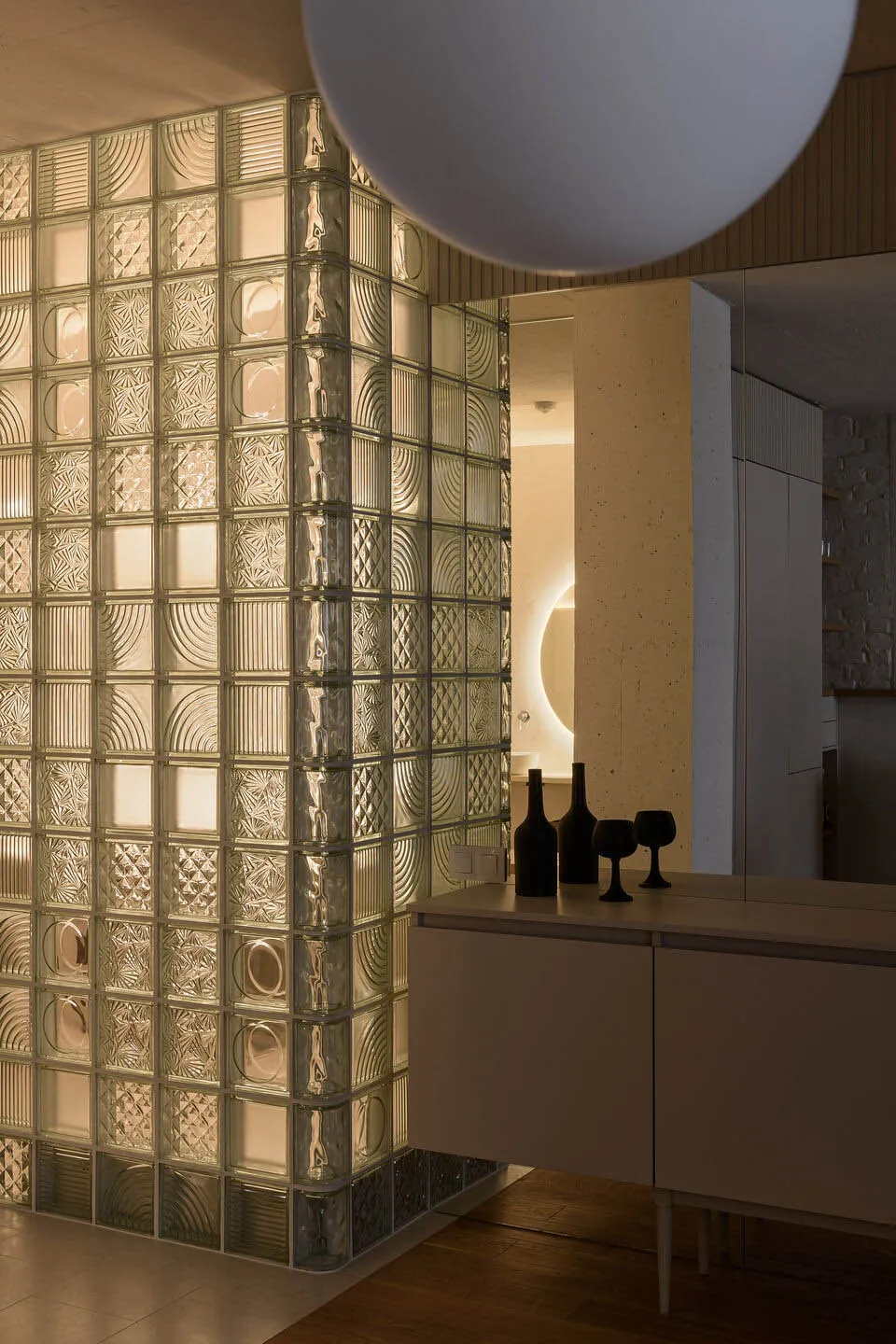 A modern residential kitchen featuring glass block walls.