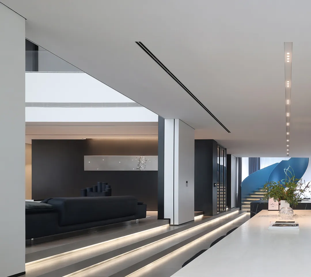 Modern living room with a minimalist design featuring a glass wall and sleek furniture.