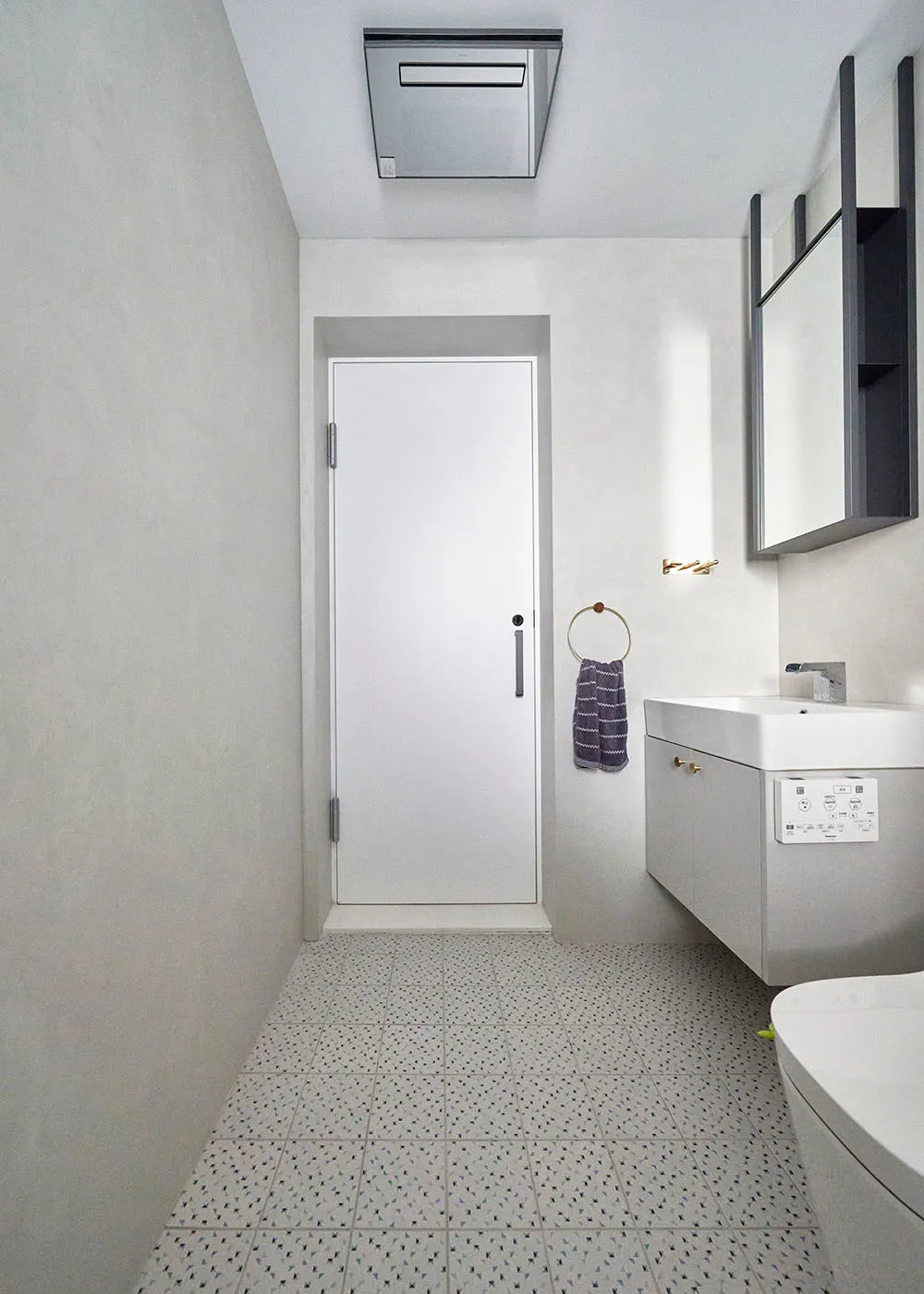 A modern bathroom with concrete tiles on the floor and light-colored walls.
