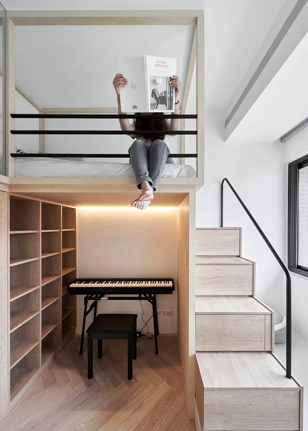 A modern living space featuring a floating bed with an integrated desk, stairs, and a piano.