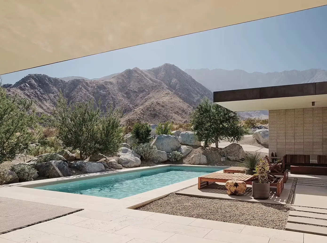 A modern minimalist exterior with a concrete pool and surrounding natural landscape.