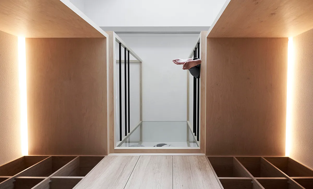A minimalist residential space featuring light-colored wood and white surfaces.
