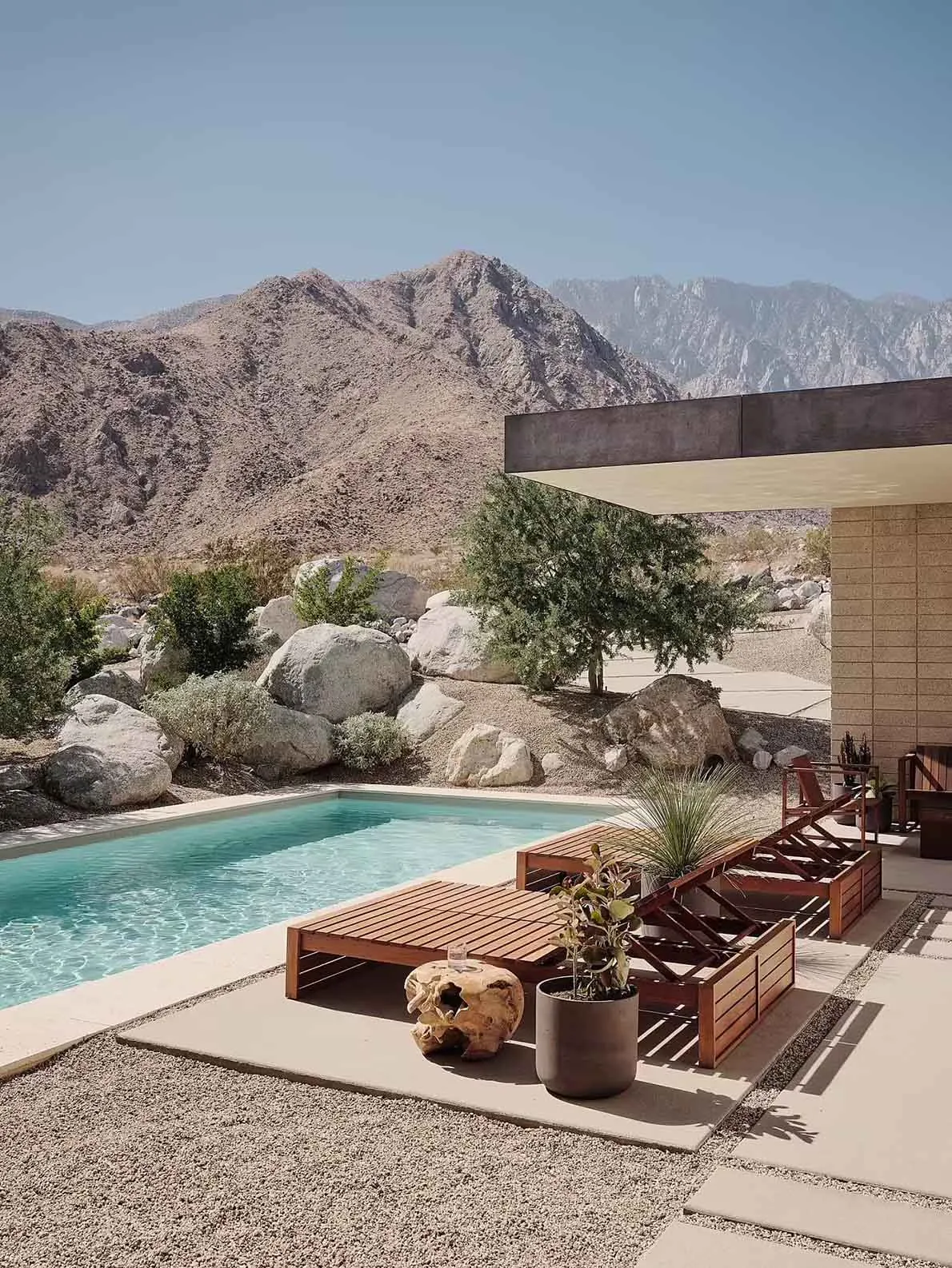 A modern residential pool area featuring concrete materials and minimalist design.