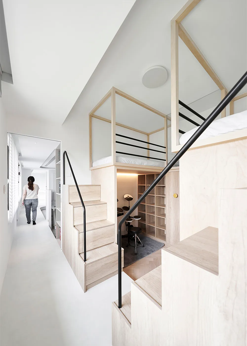 A modern minimalist living space featuring wooden stairs and glass walls.
