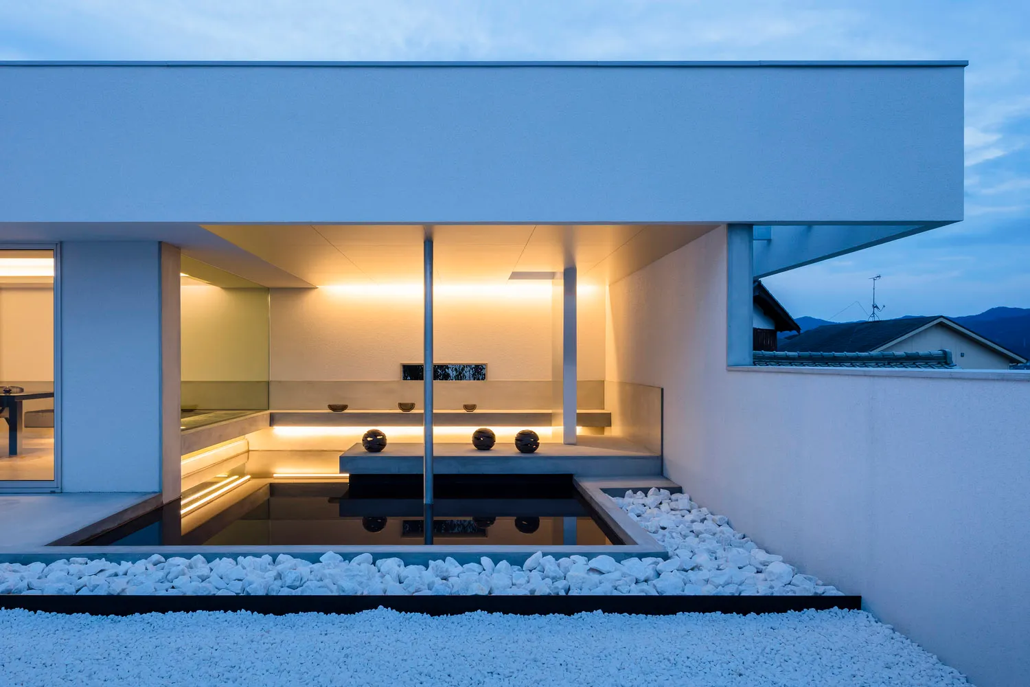 Modern minimalist residential patio featuring concrete and white gravel.