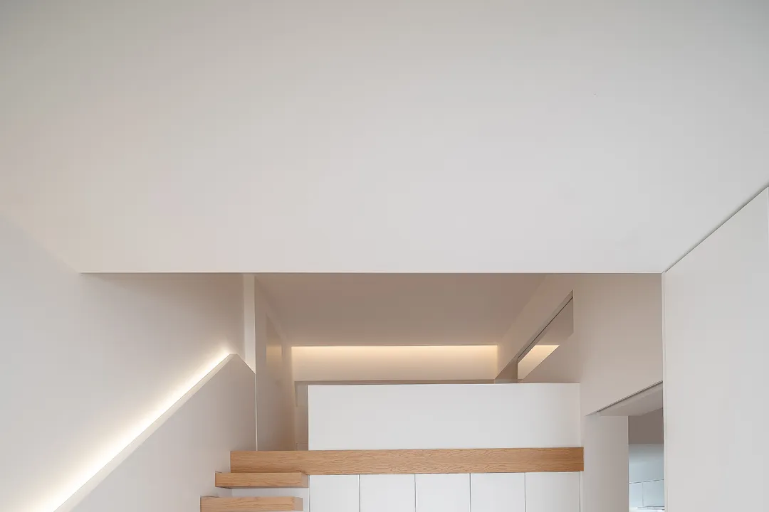 Modern minimalist interior with white walls and wooden accents.