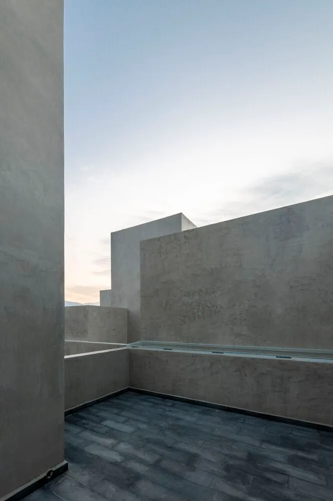 A minimalist rooftop exterior featuring a concrete structure with a clear sky background.