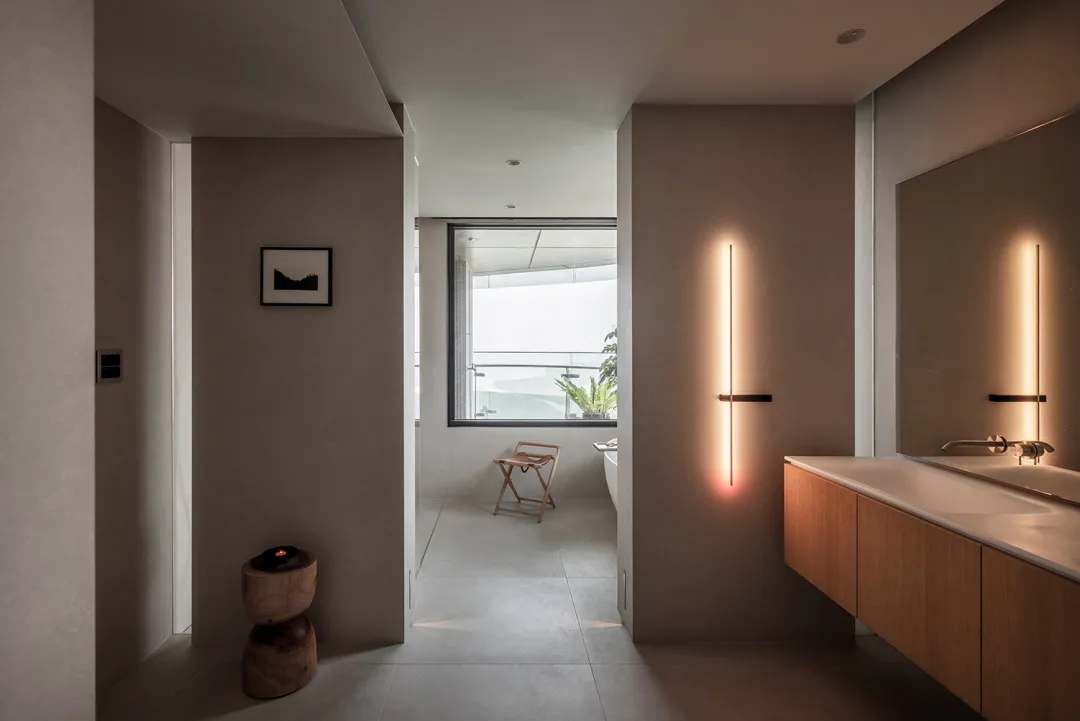 Modern minimalist bathroom featuring concrete walls and a floating wooden vanity with a rectangular mirror above it. The spac