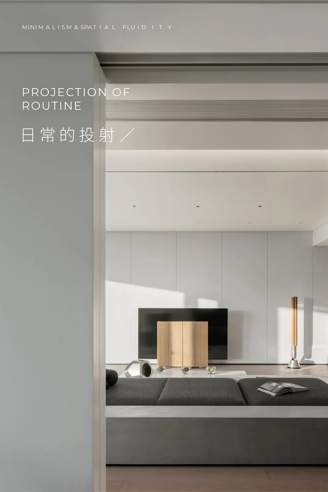 A minimalist living room with a grey sofa, a wooden cabinet, and a television.