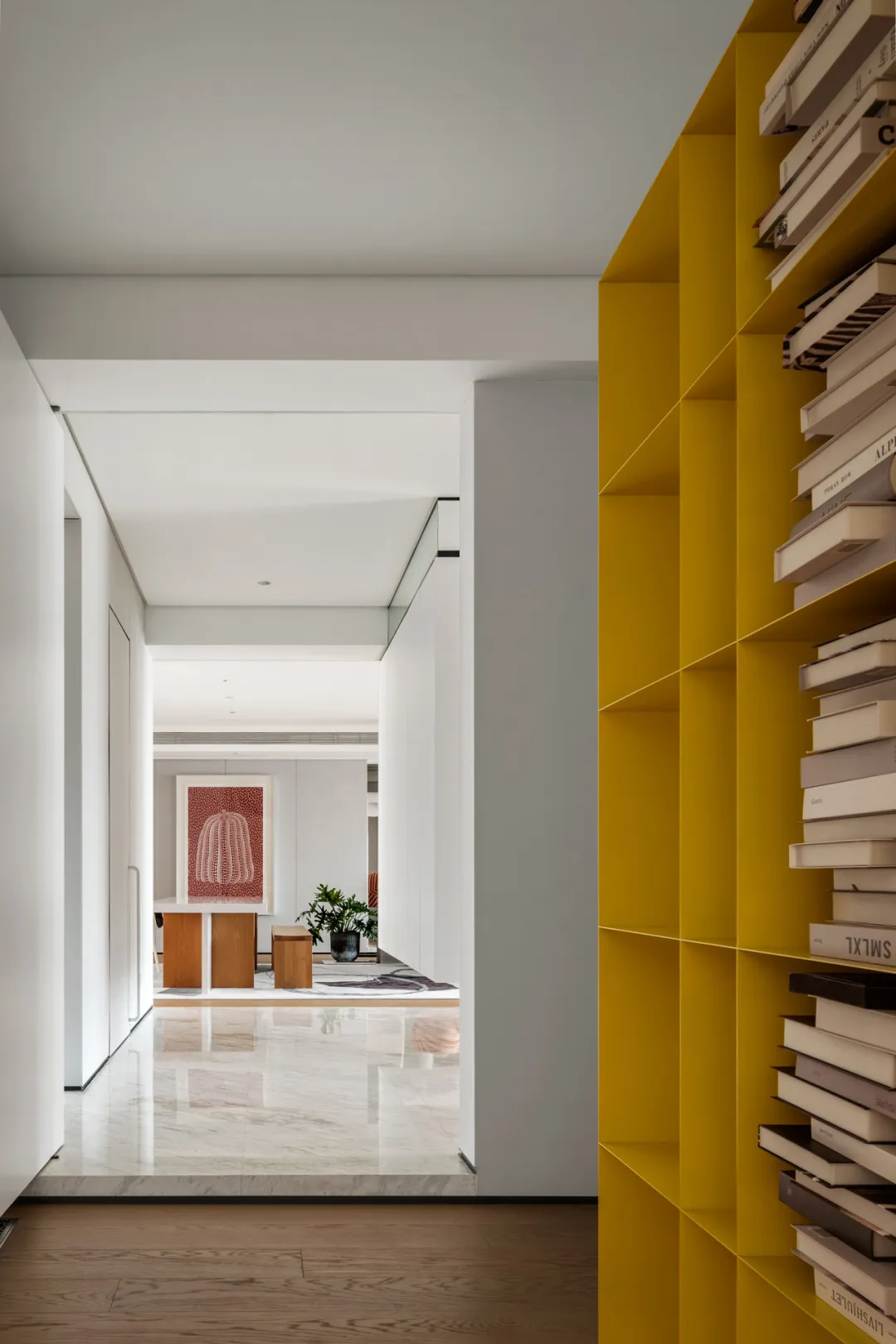 A modern minimalist living room showcasing vibrant yellow shelving units filled with books.