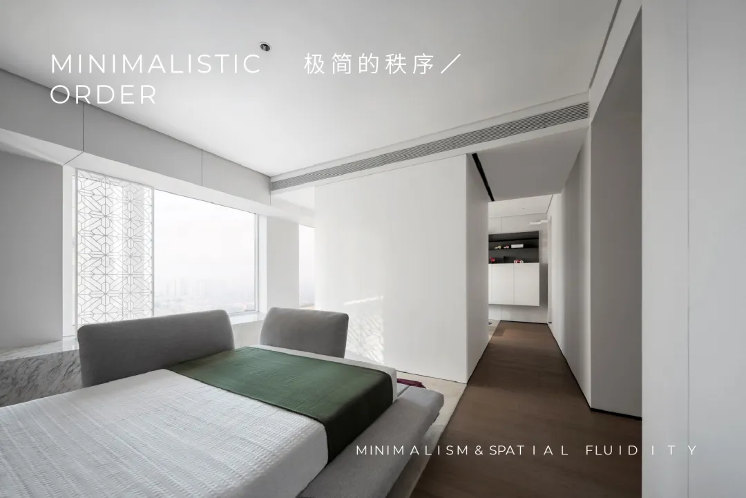 Modern minimalist bedroom featuring white walls, grey furniture, and a green throw blanket.