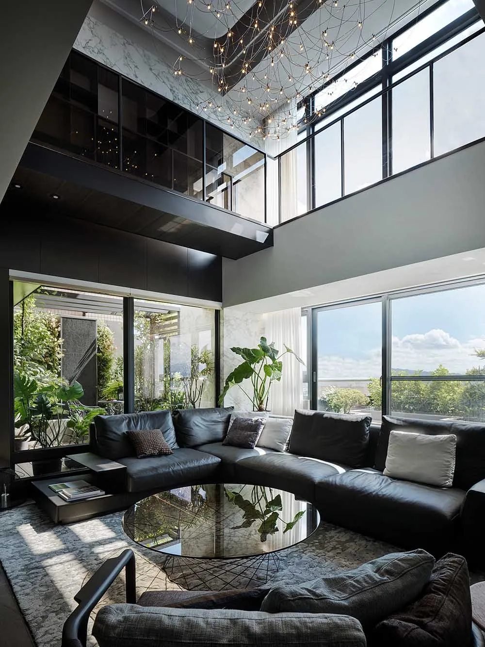 Modern living room with marble accents, glass windows, and black leather sofa