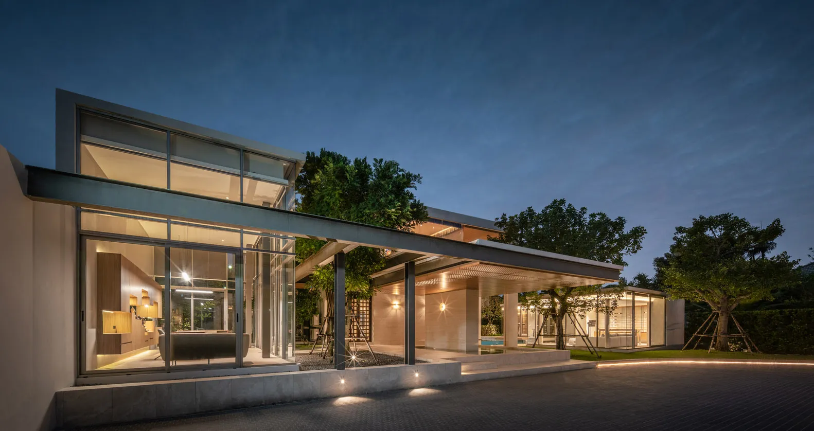 A modern residential building with concrete exterior and illuminated features at night
