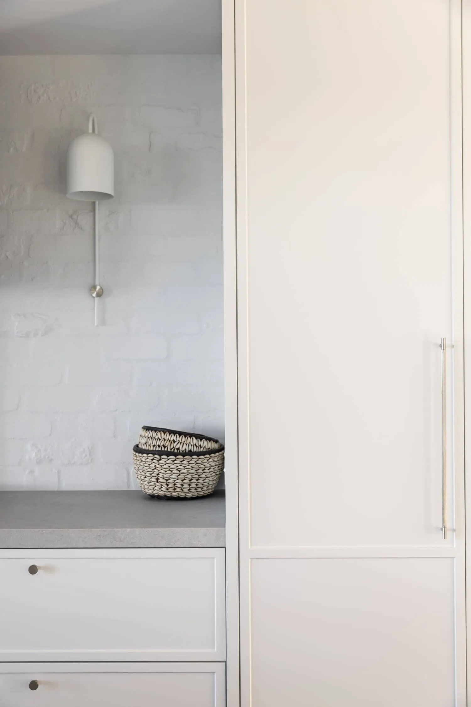 Modern minimalist interior design featuring concrete surfaces and sleek white cabinetry.