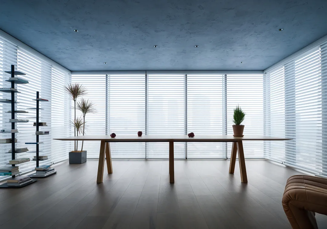 Minimalist office space featuring wooden furniture and glass walls.
