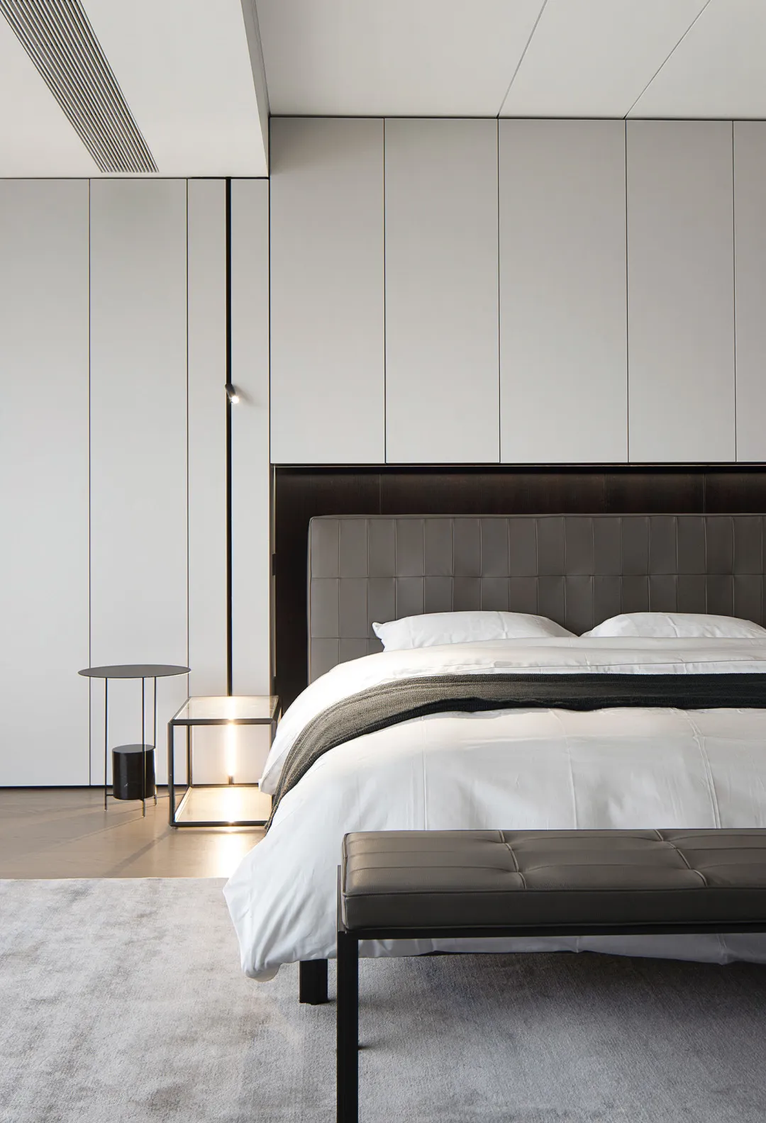 A minimalist bedroom with a modern bed featuring textured cotton bedding.