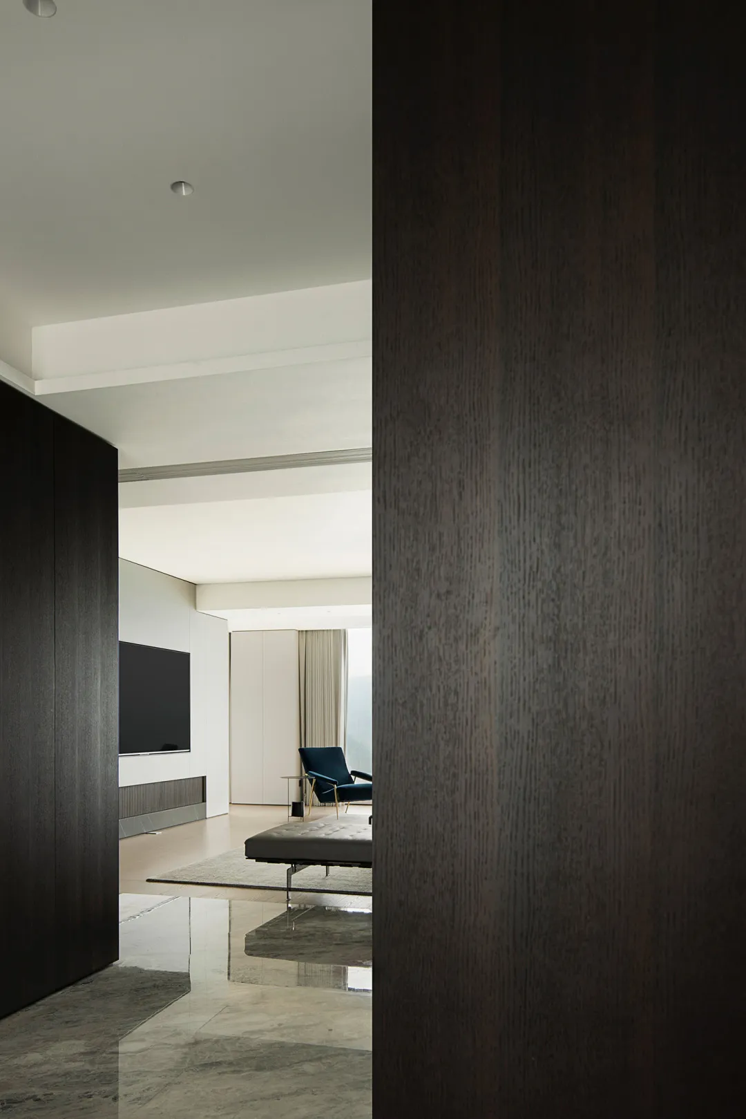 A modern, minimalist living room featuring metallic steel walls and marble flooring.