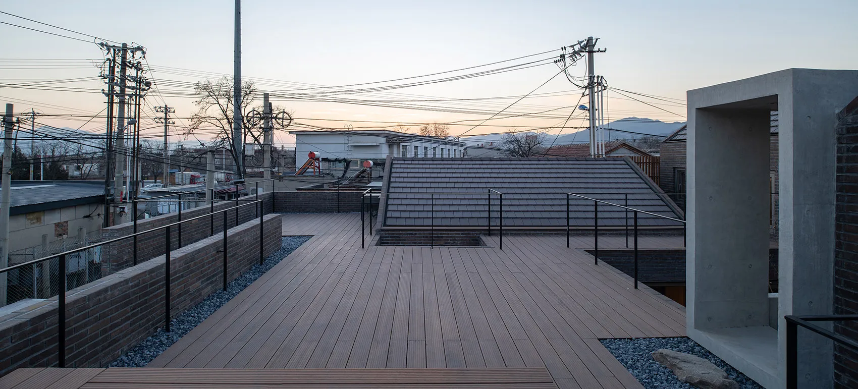 A rooftop terrace featuring modern design elements such as wood flooring and concrete structural elements.