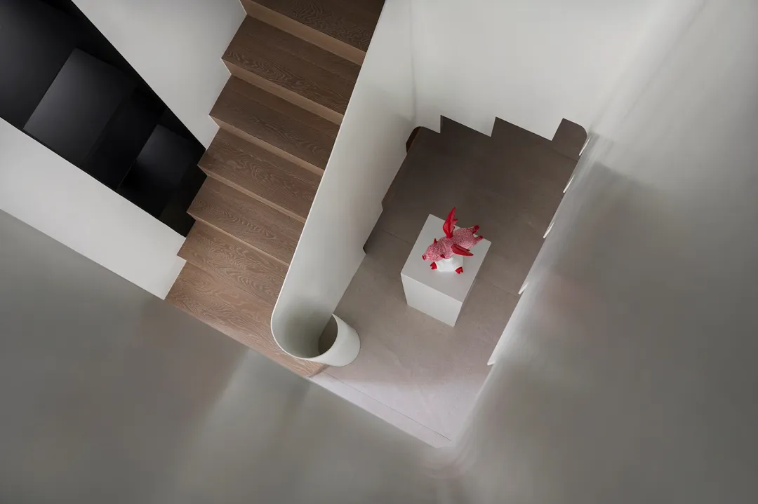 A modern staircase with wooden steps and a concrete handrail