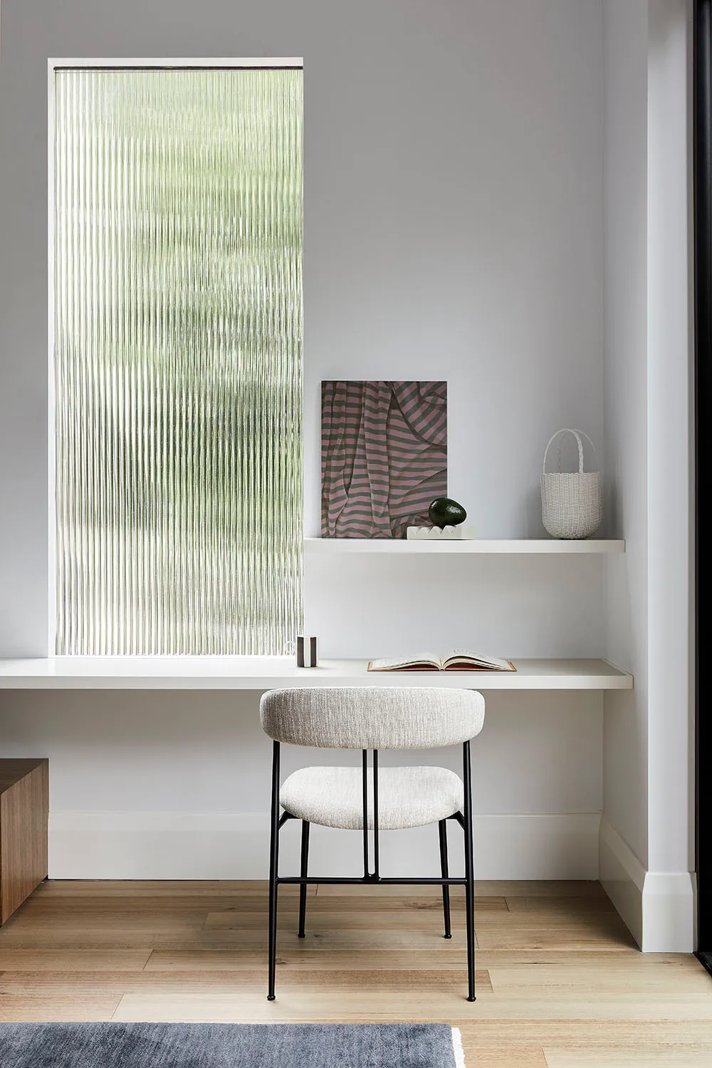 Industrial home office with a glass window, featuring minimalistic design and functional workspace.