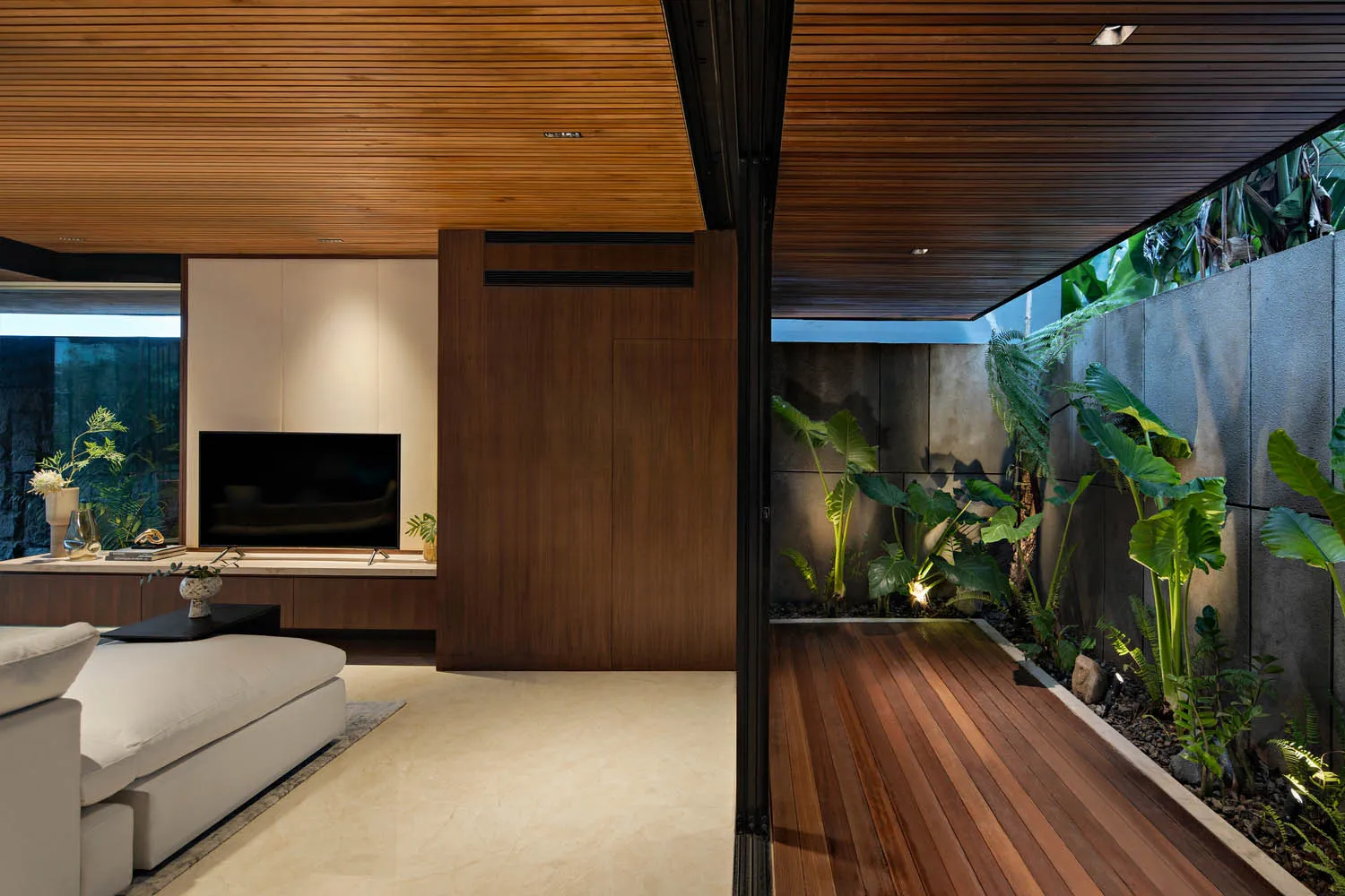 A modern living room featuring wooden elements and a private garden section.