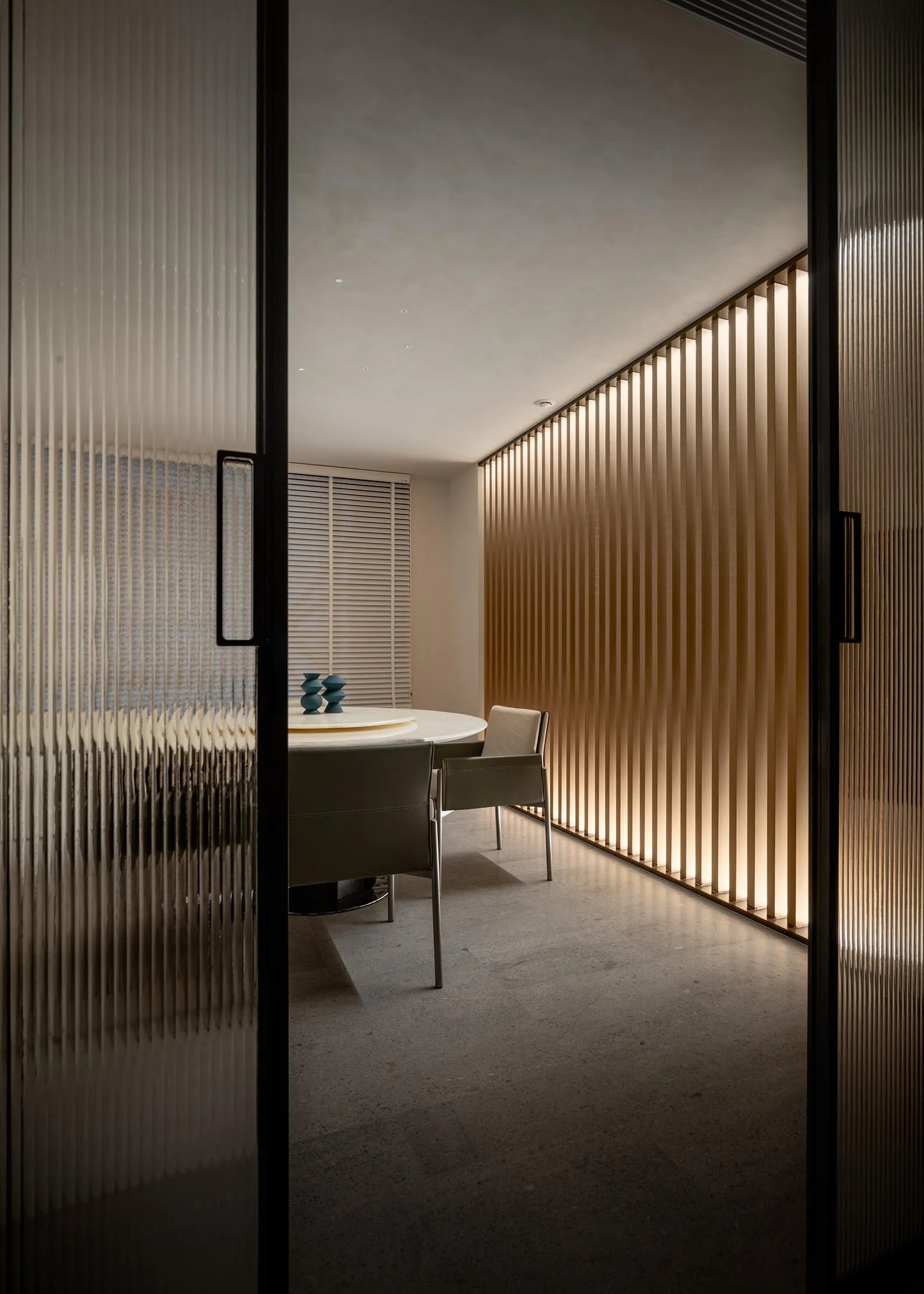 A minimalist dining room with wooden walls and lighting